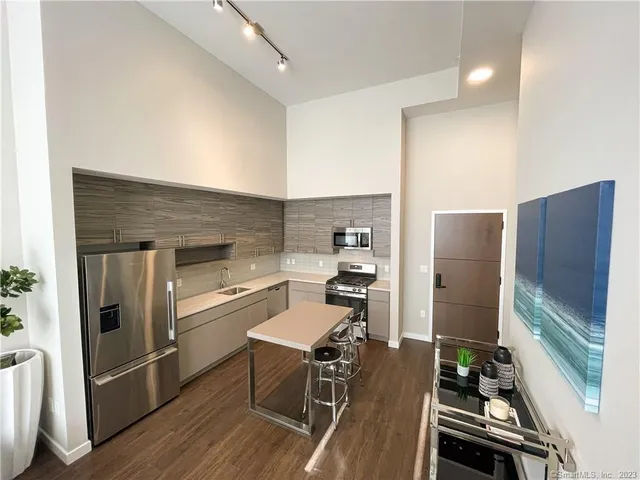 a kitchen with wooden floor and stainless steel appliances
