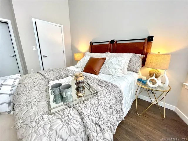 a bedroom with a bed and wooden floor