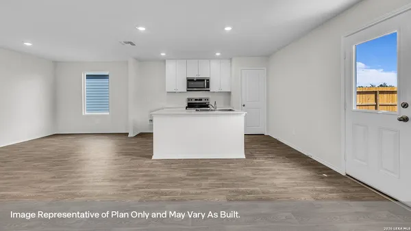 a kitchen with stainless steel appliances granite countertop a stove top oven a sink and a refrigerator