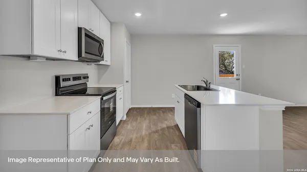a kitchen with stainless steel appliances a white stove top oven a sink a refrigerator and white cabinets