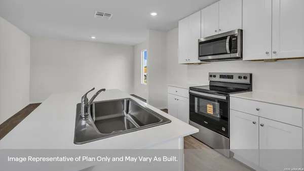 a kitchen with a sink a microwave and cabinets