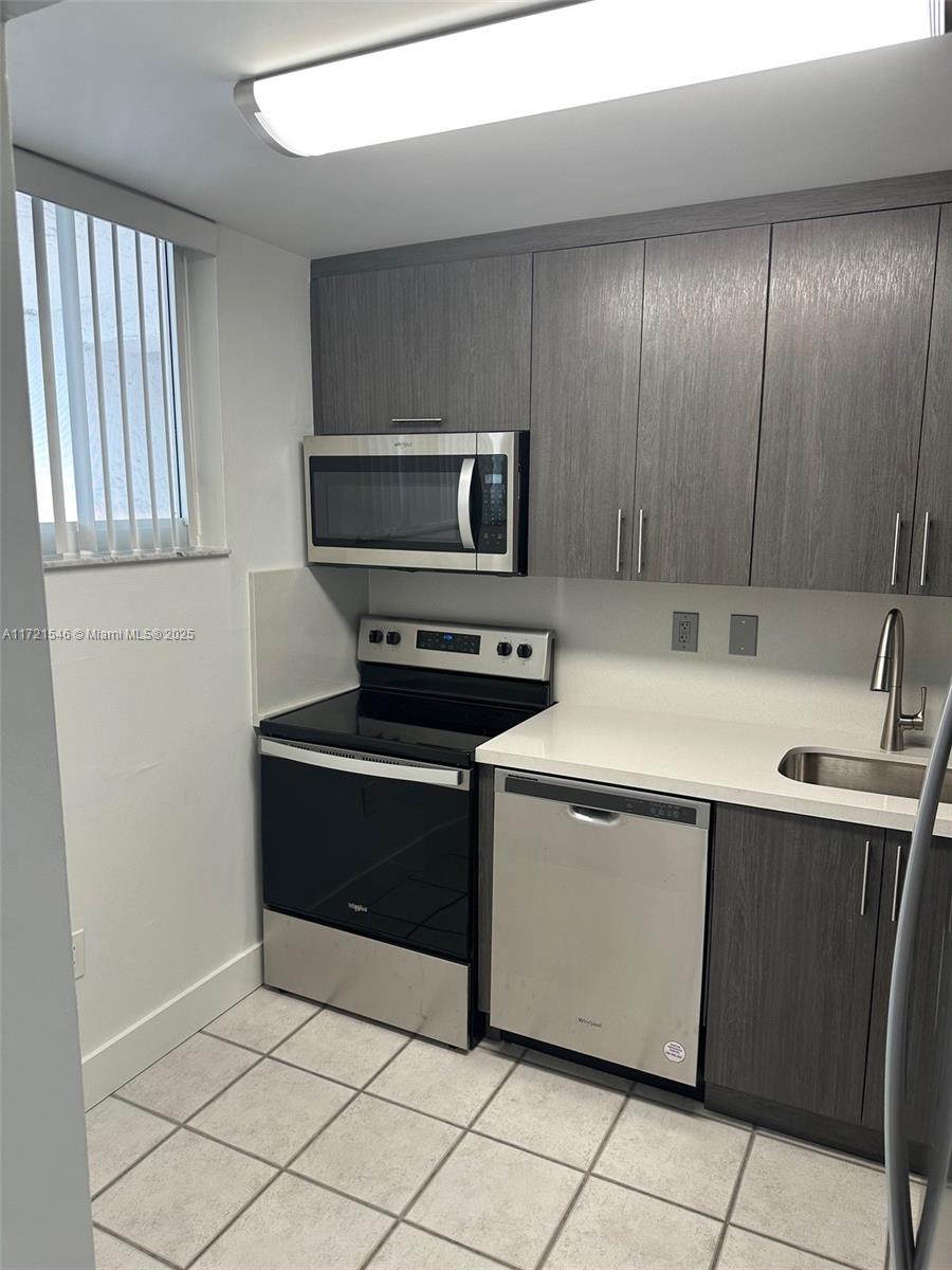 1666 West Avenue, Unit 512 Miami Beach, FL 33139 - Photo 11 of 20 a kitchen with a sink and a microwave
