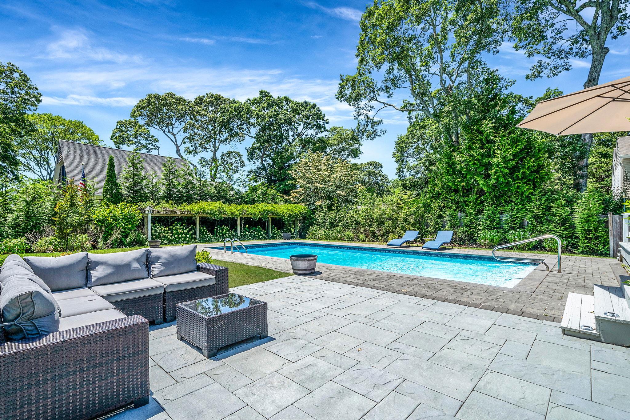 a view of a patio with swimming pool and furniture
