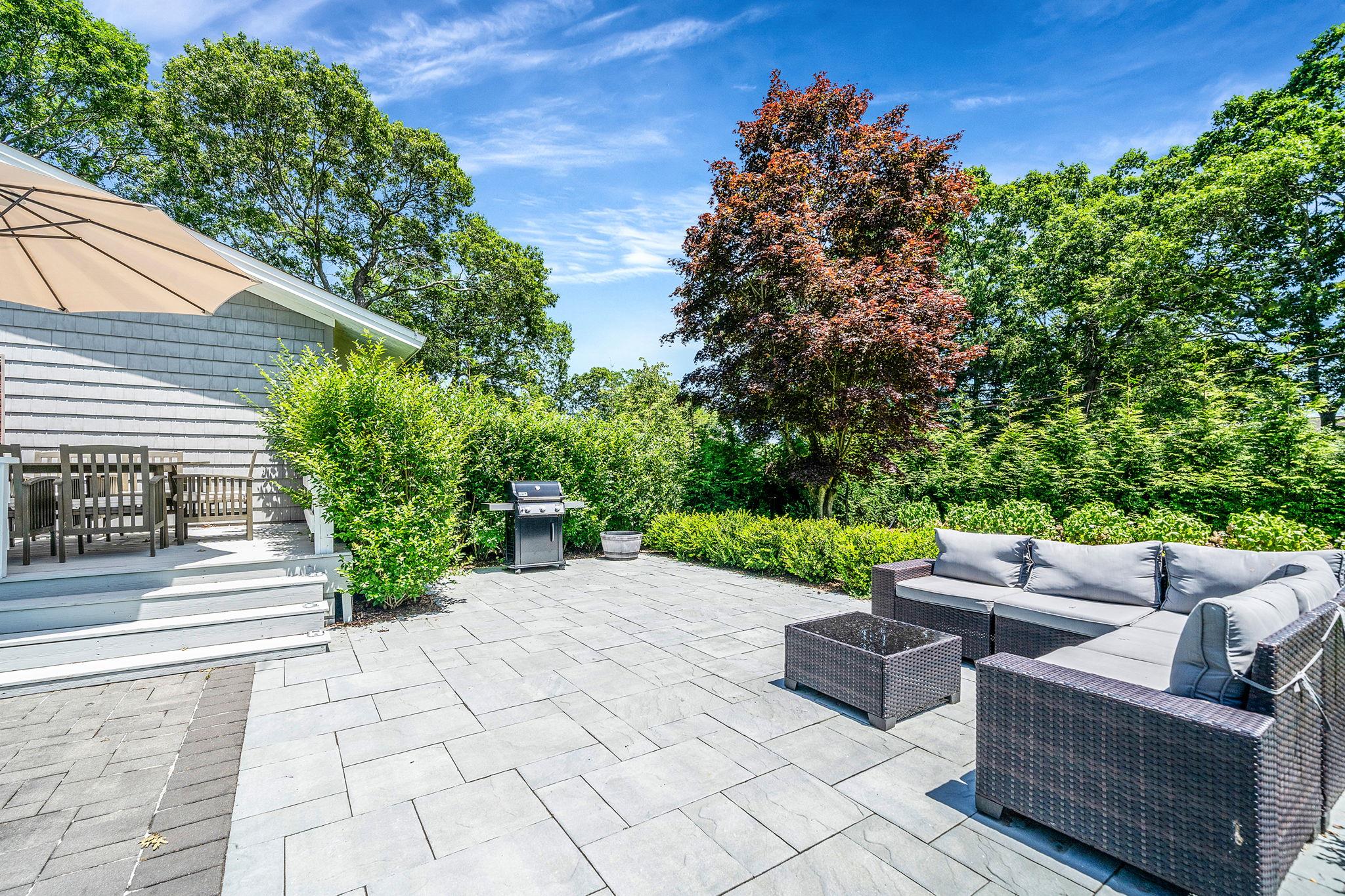 3 Crestview Drive Remsenburg, NY 11960 - Photo 15 of 21 a view of a patio with couches and a potted plant on a brick wall