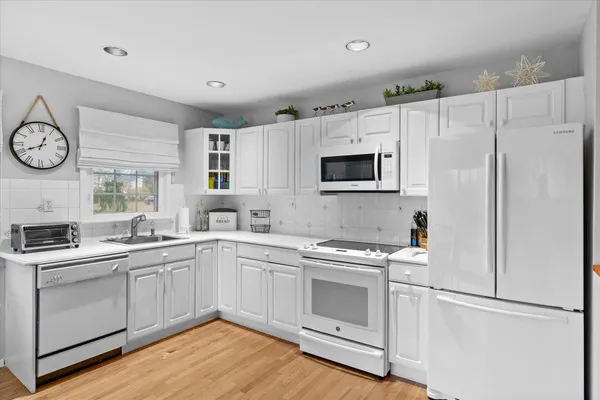 a kitchen with cabinets stainless steel appliances and wooden floor