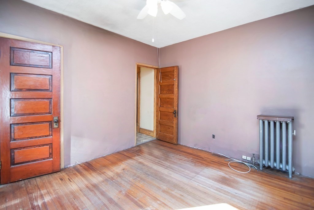 84 Orange Street Springfield, MA 01108 - Photo 12 of 42 a view of an empty room with a window and wooden floor