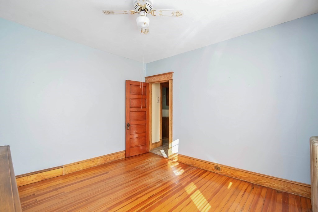 84 Orange Street Springfield, MA 01108 - Photo 13 of 42 a view of an empty room with wooden floor and a window