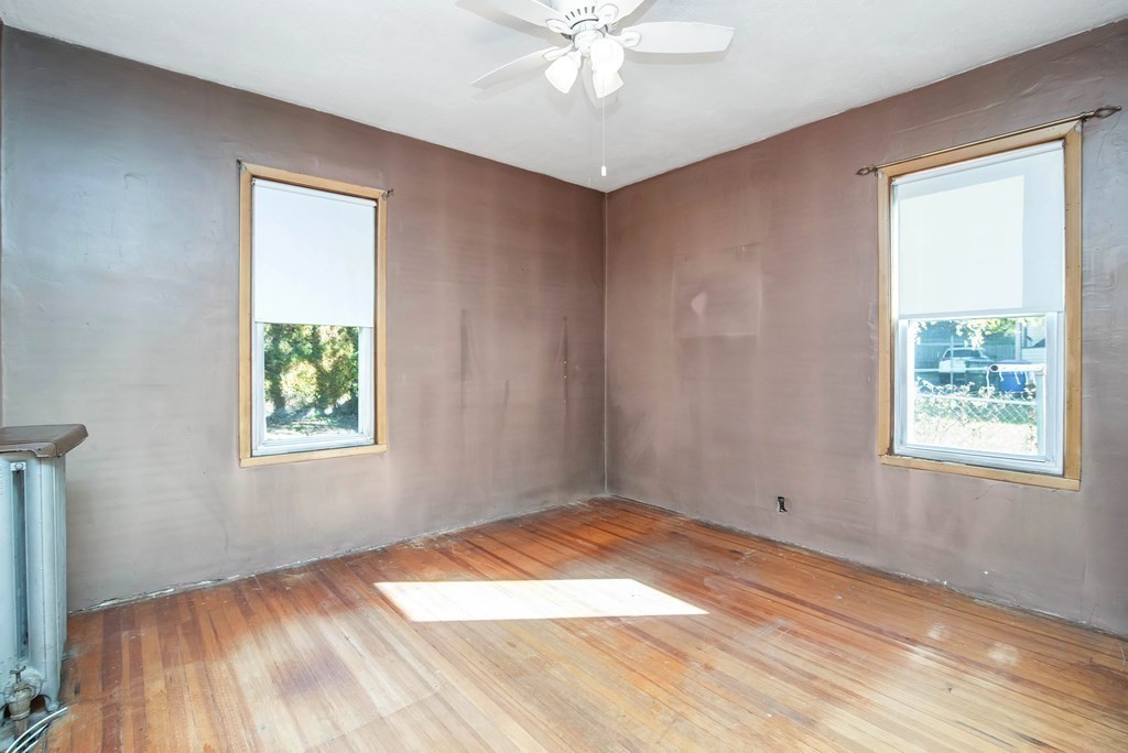 84 Orange Street Springfield, MA 01108 - Photo 14 of 42 a view of an empty room with wooden floor and a window