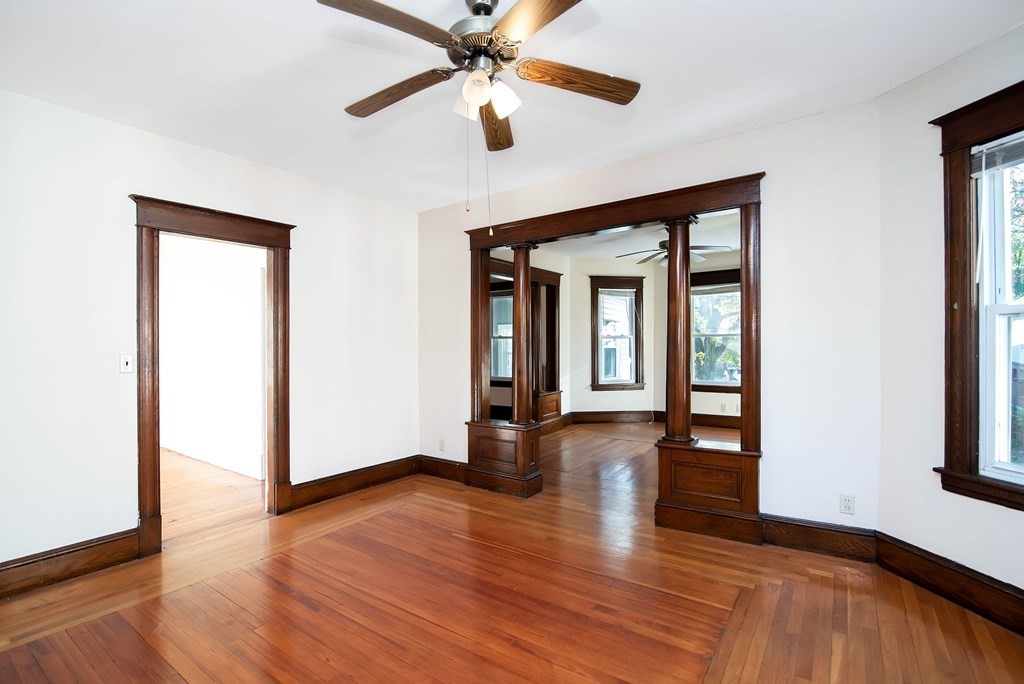 84 Orange Street Springfield, MA 01108 - Photo 18 of 42 an empty room with wooden floor chandelier fan and windows