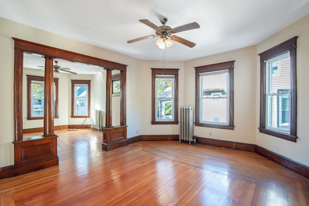 84 Orange Street Springfield, MA 01108 - Photo 19 of 42 a view of an empty room with wooden floor and a window