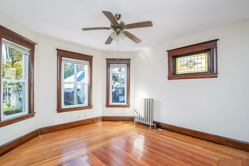 84 Orange Street Springfield, MA 01108 - Photo 23 of 42 a view of an empty room with wooden floor and a window