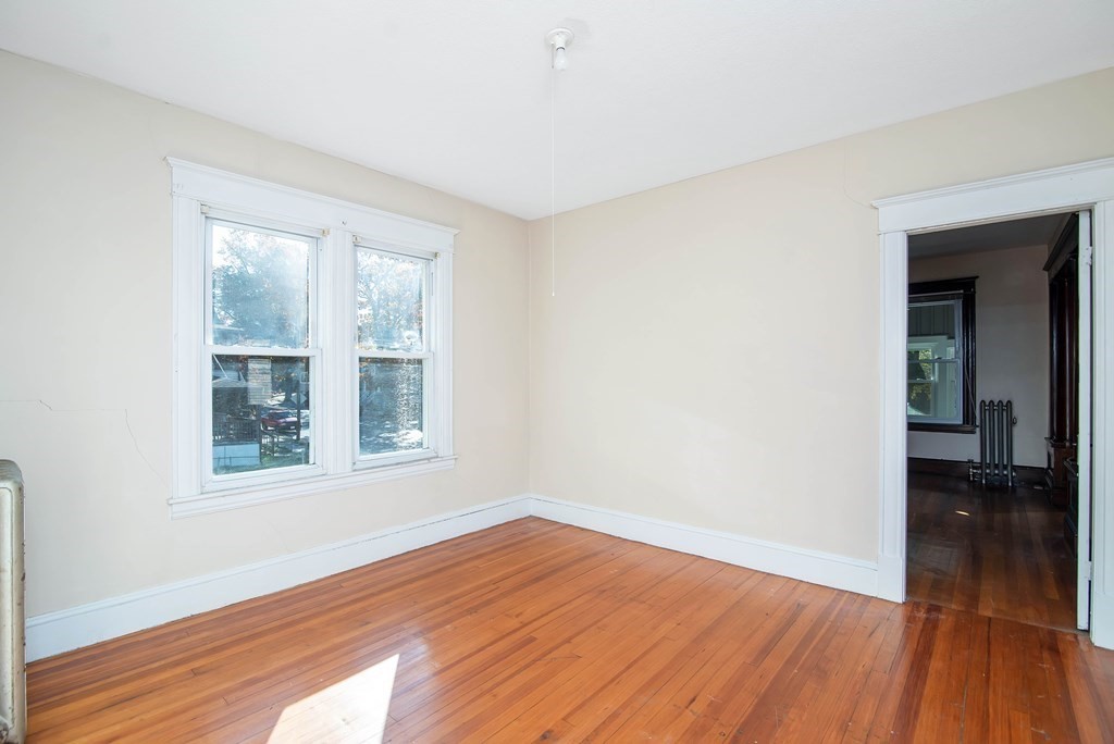 84 Orange Street Springfield, MA 01108 - Photo 24 of 42 a view of an empty room with wooden floor and a window