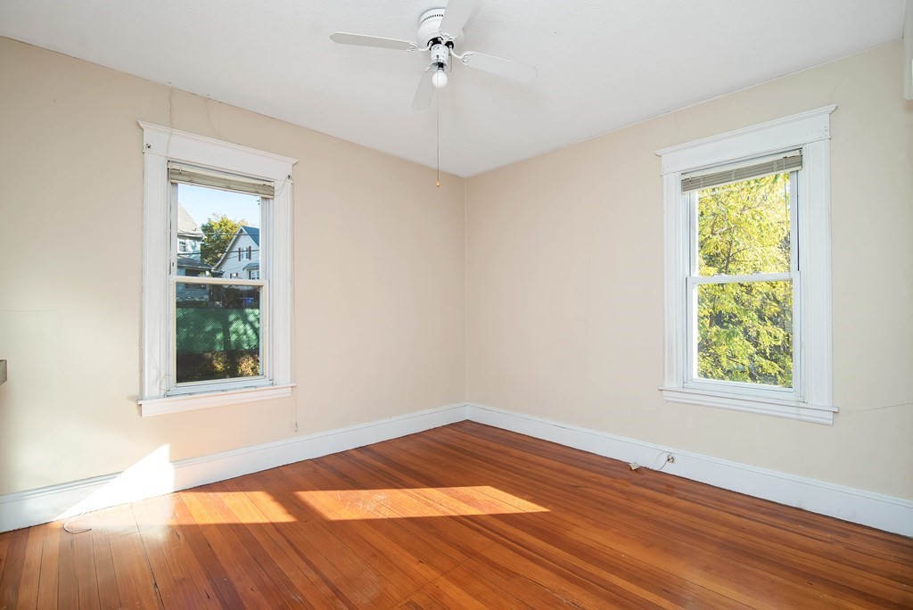 84 Orange Street Springfield, MA 01108 - Photo 26 of 42 a view of an empty room with wooden floor and a window