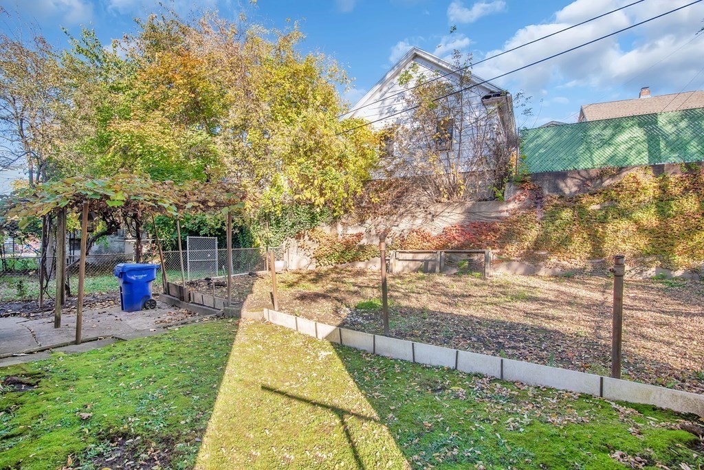 84 Orange Street Springfield, MA 01108 - Photo 39 of 42 a view of a backyard with couches plants and large trees