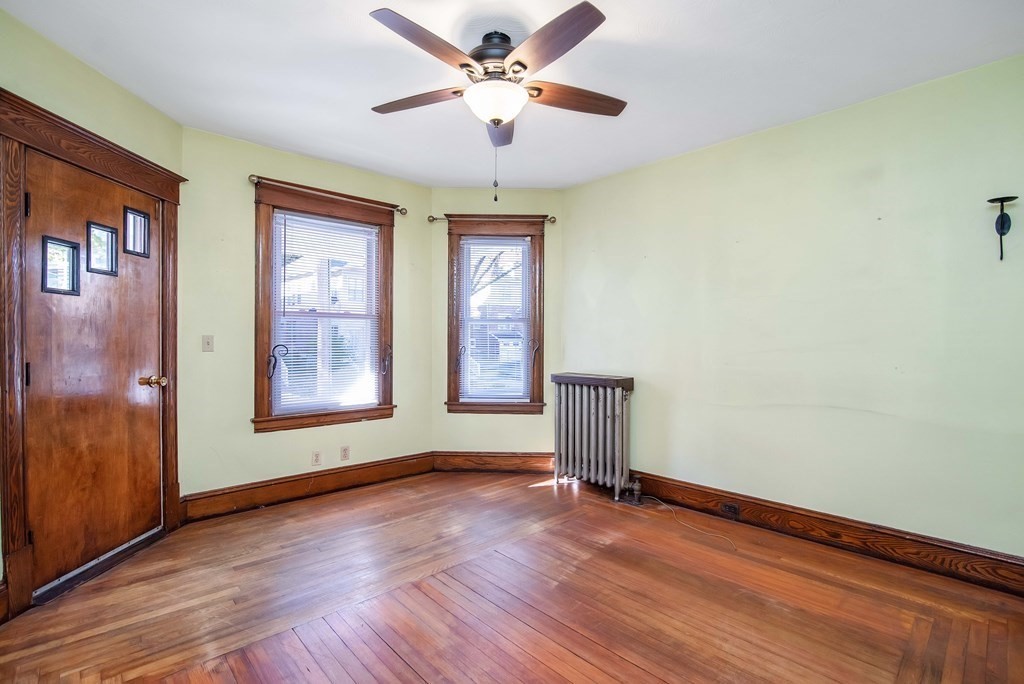 84 Orange Street Springfield, MA 01108 - Photo 4 of 42 an empty room with wooden floor chandelier fan and windows
