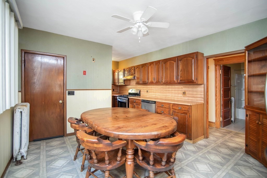 84 Orange Street Springfield, MA 01108 - Photo 7 of 42 a kitchen with stainless steel appliances kitchen island granite countertop a refrigerator a stove a sink a dining table and chairs with wooden floor
