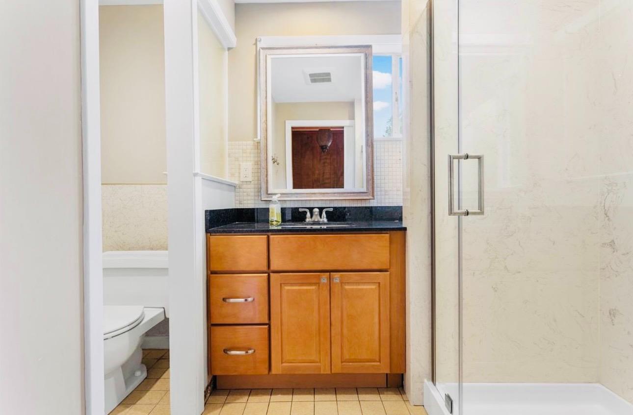 1556 E Street Hayward, CA 94541 - Photo 13 of 65 a bathroom with a sink a mirror and a shower