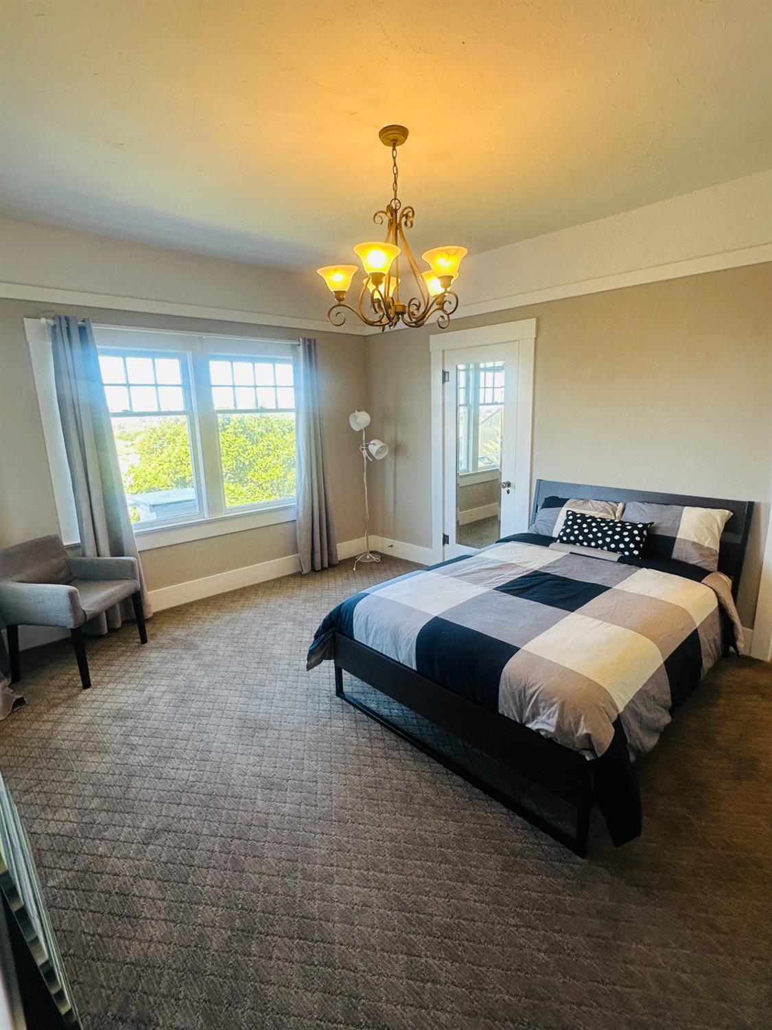 1556 E Street Hayward, CA 94541 - Photo 20 of 65 a spacious bedroom with a bed and a chandelier