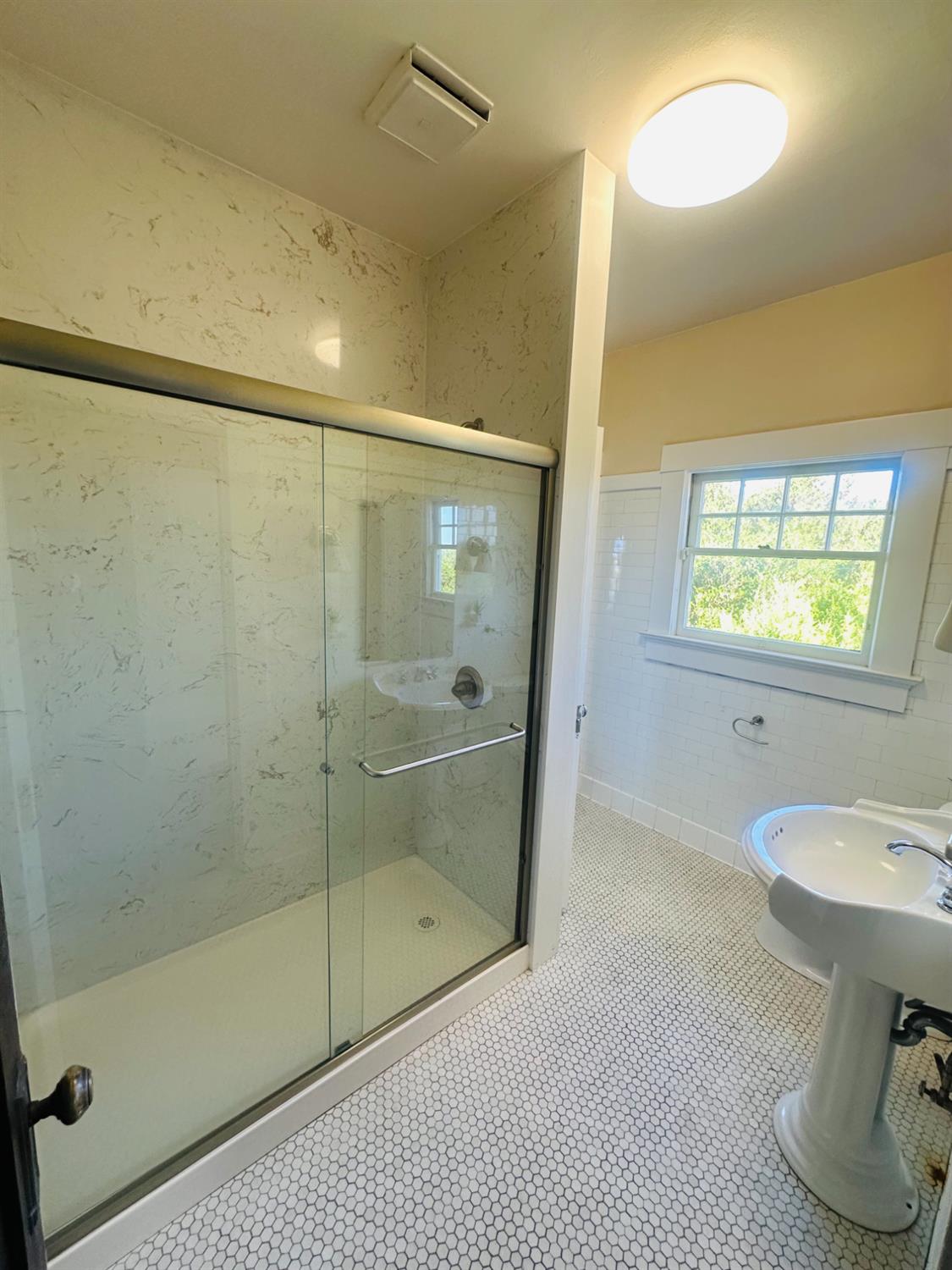 1556 E Street Hayward, CA 94541 - Photo 22 of 65 a bathroom with a sink shower and a mirror