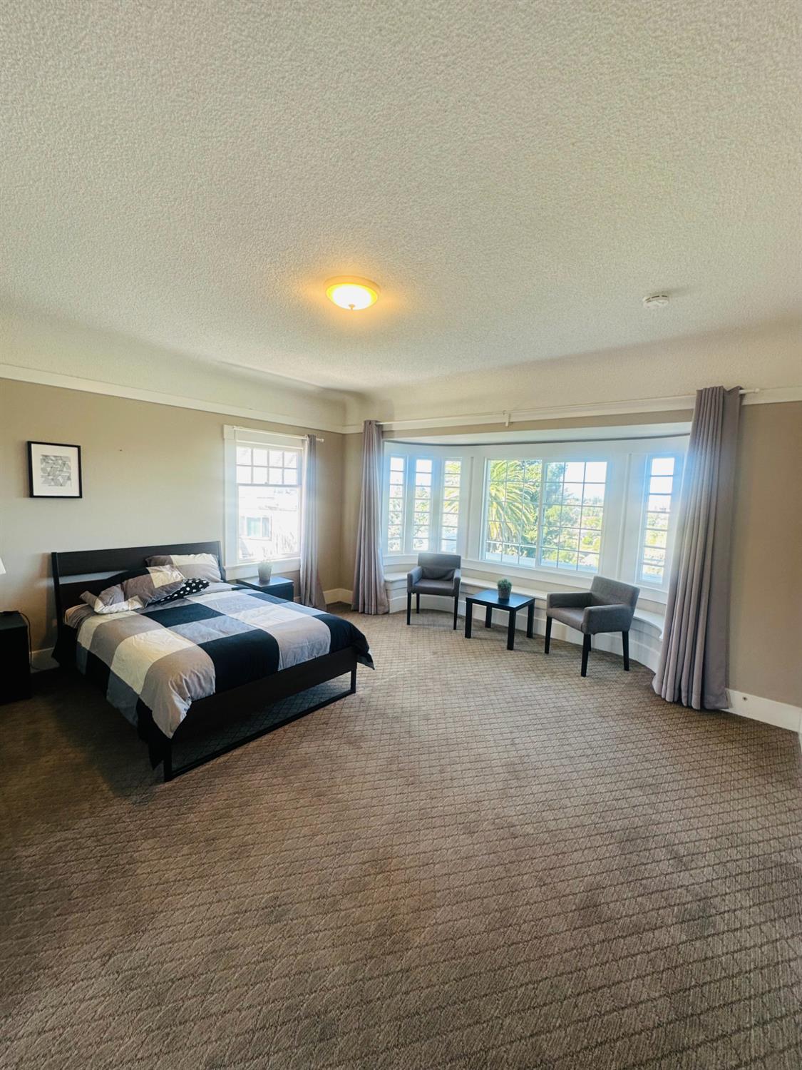 1556 E Street Hayward, CA 94541 - Photo 23 of 65 a spacious bedroom with a bed and a chandelier