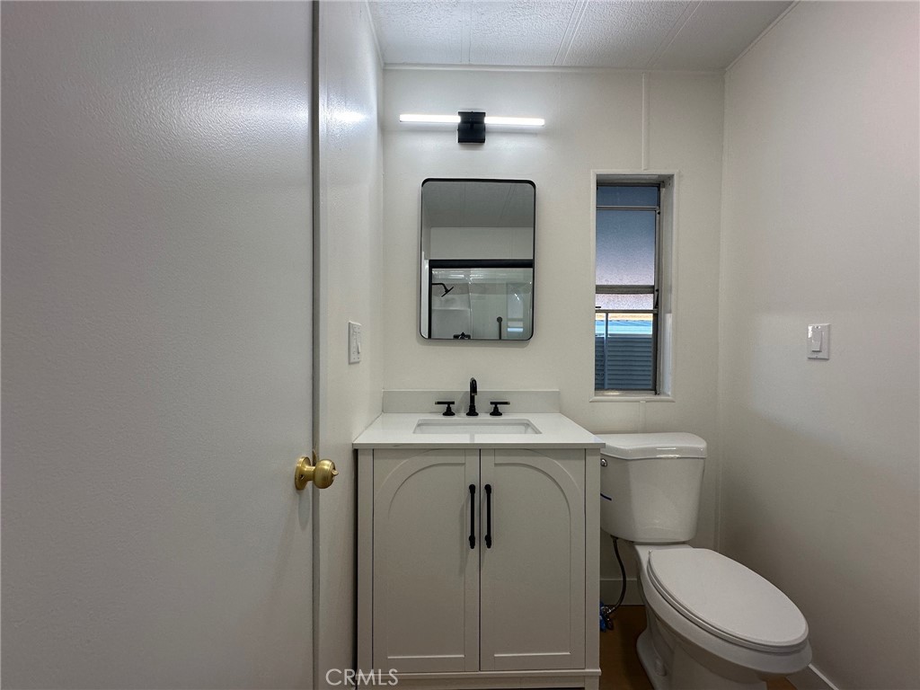 650-291 South Rancho Santa Fe Road San Marcos, CA 92078 - Photo 24 of 40 a bathroom with a toilet a sink and mirror