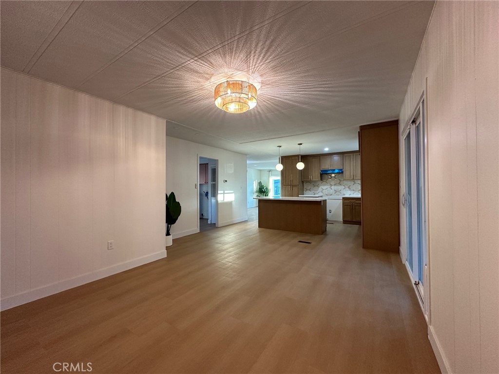 650-291 South Rancho Santa Fe Road San Marcos, CA 92078 - Photo 29 of 40 a view of a big room with wooden floor and a kitchen