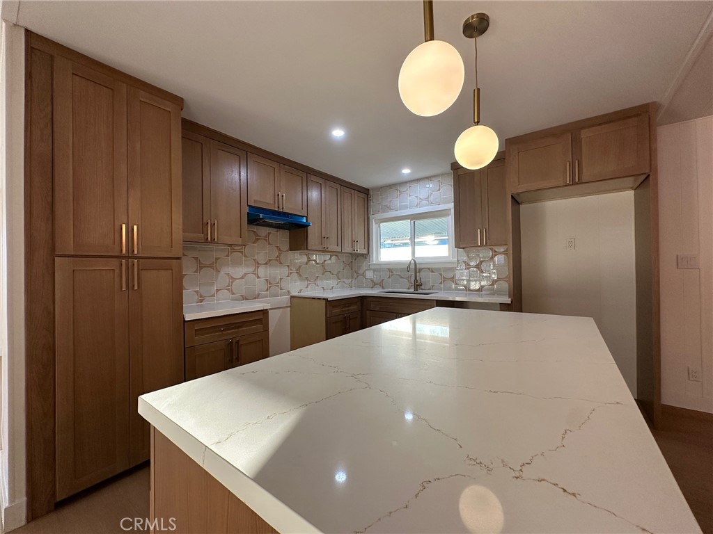 650-291 South Rancho Santa Fe Road San Marcos, CA 92078 - Photo 32 of 40 a large kitchen with stainless steel appliances a large counter top space cabinets and a chandelier