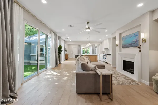 a living room with furniture a fireplace and a floor to ceiling window