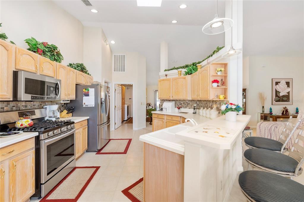 4670 Southwest 158th St Road Ocala, FL 34473 - Photo 12 of 42 a kitchen with stainless steel appliances kitchen island granite countertop a stove a sink and a refrigerator