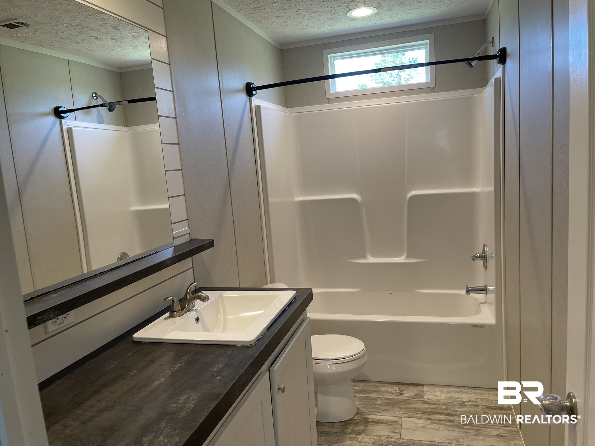 16802 County Road 87 Elberta, AL 36530 - Photo 16 of 19 Bathroom featuring a textured ceiling, vanity, washtub / shower combination, and light wood-style flooring