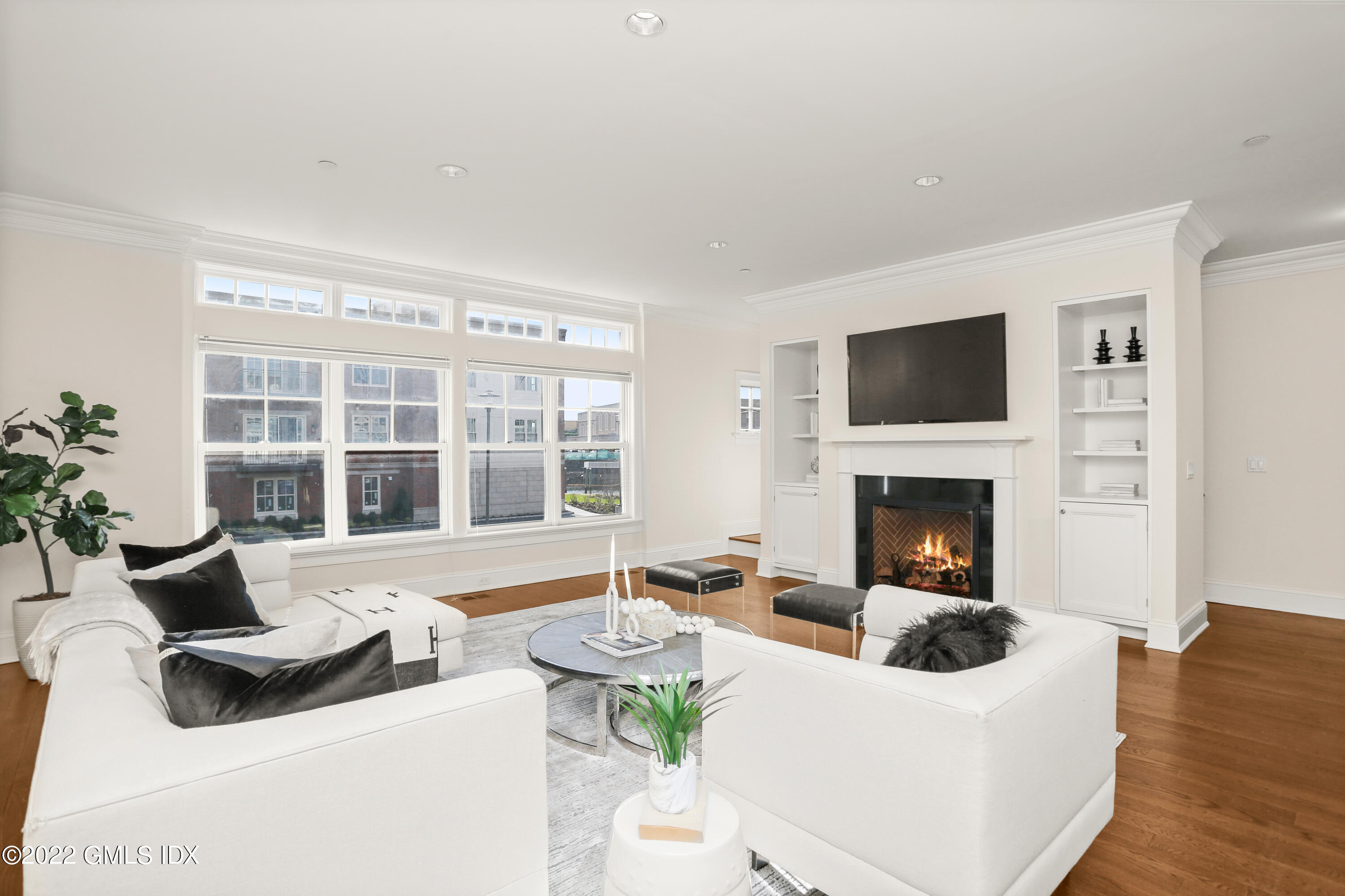 88 South Water Street, Unit 302 Greenwich, CT 06830 - Photo 4 of 21 a living room with furniture a fireplace and a flat screen tv