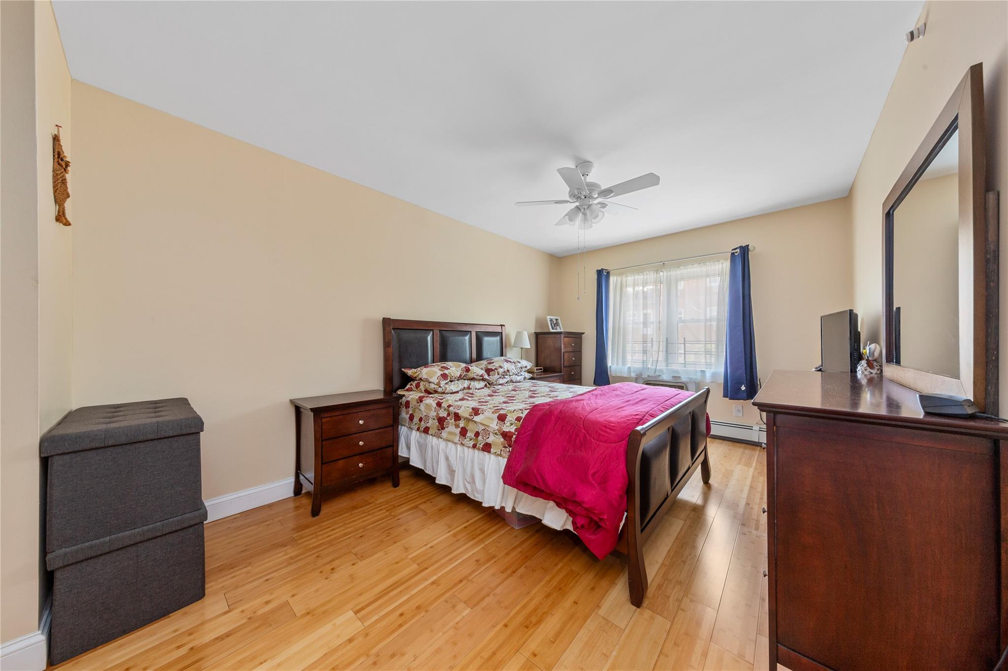 71-09 Sutton Place, Unit 2 Queens, NY 11365 - Photo 7 of 20 Bedroom with light wood-type flooring, baseboards, ceiling fan, and a baseboard heating unit