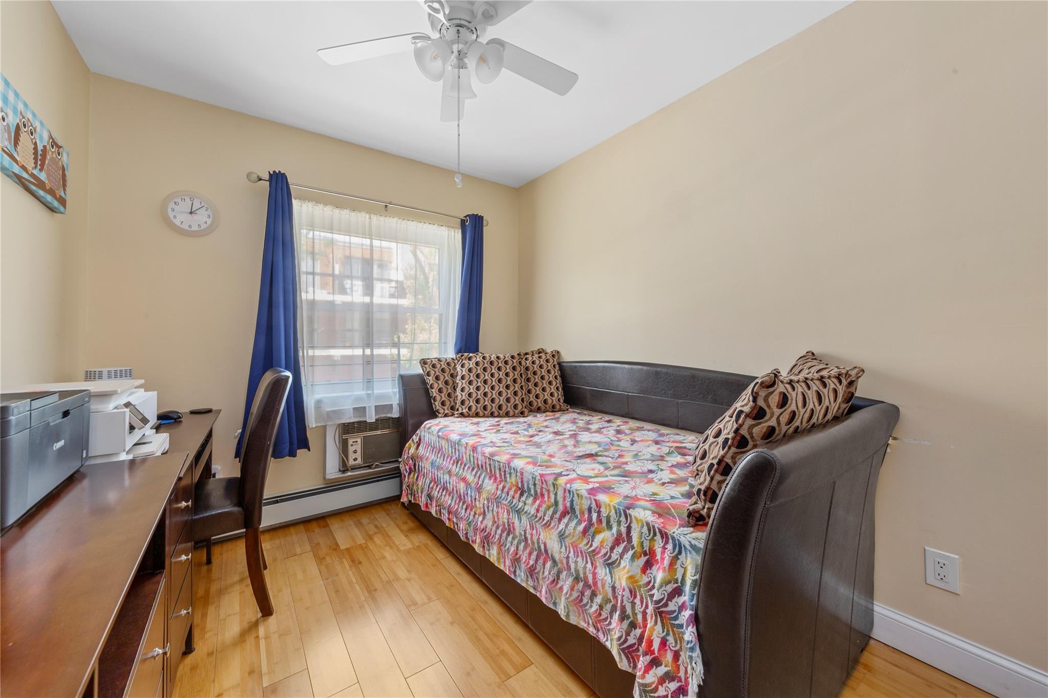 71-09 Sutton Place, Unit 2 Queens, NY 11365 - Photo 9 of 20 Bedroom featuring a baseboard radiator, light wood-type flooring, and ceiling fan