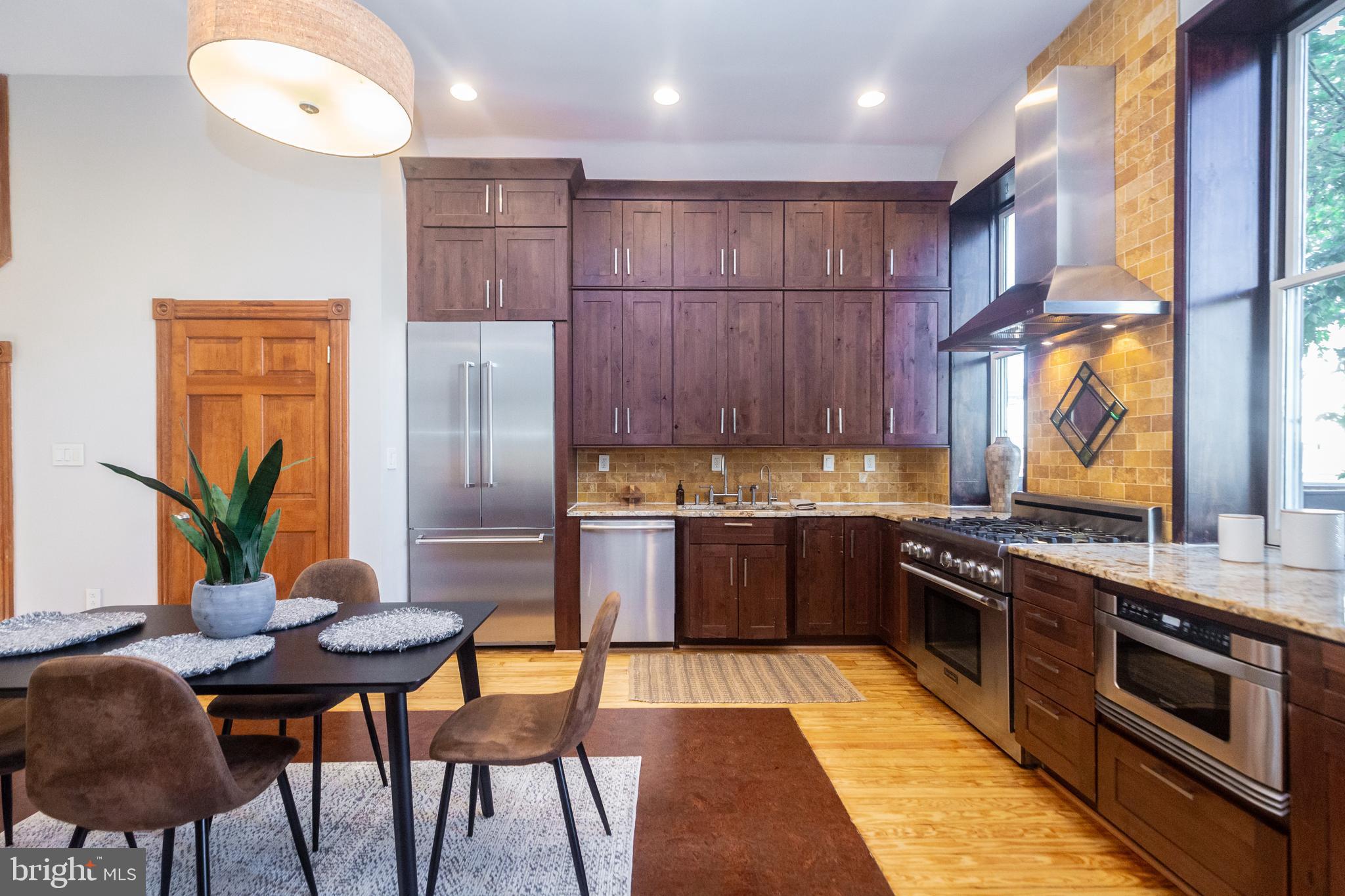 1311 Riggs Street Northwest Washington, DC 20009 - Photo 18 of 101 a kitchen with stainless steel appliances granite countertop a stove a sink and a refrigerator