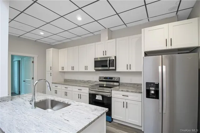 a kitchen with stainless steel appliances granite countertop a refrigerator sink and stove