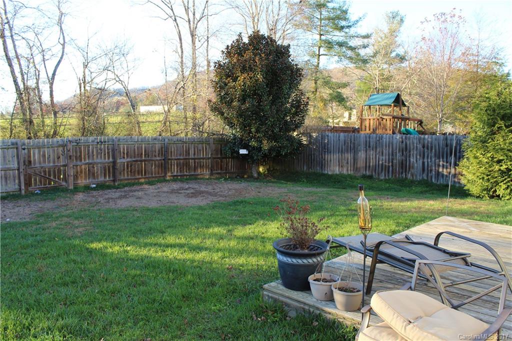 164 Wildbriar Road Fletcher, NC 28732 - Photo 16 of 16 a view of a backyard with table and chairs potted plants and wooden fence