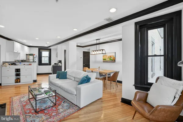 a living room with furniture and view of kitchen
