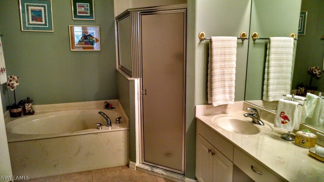 4629 Fairloop Run Lehigh Acres, FL 33973 - Photo 11 of 24 a bathroom with a tub sink and a window
