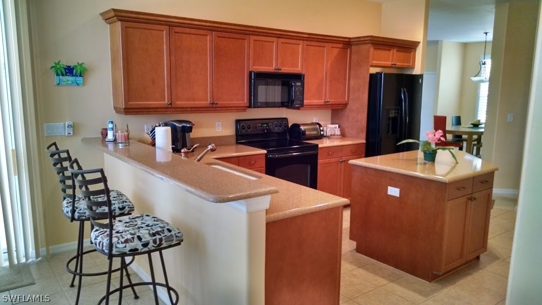 4629 Fairloop Run Lehigh Acres, FL 33973 - Photo 3 of 24 a kitchen that has a sink and a stove in it