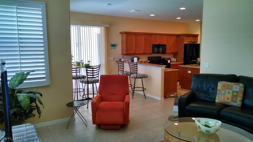 4629 Fairloop Run Lehigh Acres, FL 33973 - Photo 4 of 24 a living room with furniture kitchen view and a potted plant