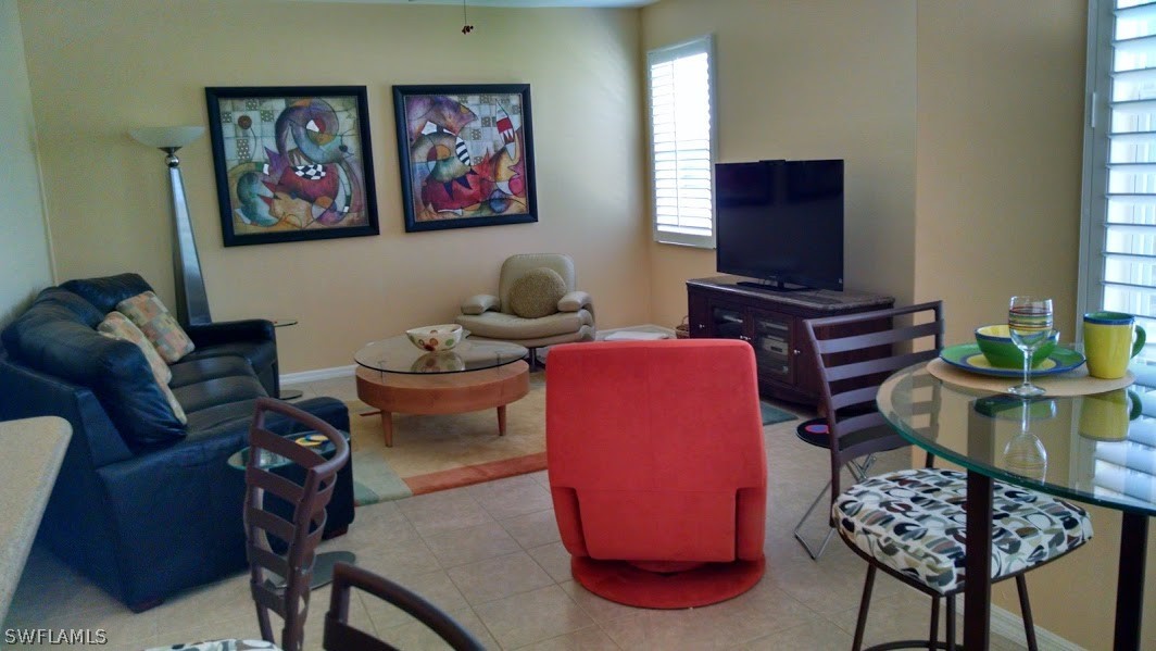 4629 Fairloop Run Lehigh Acres, FL 33973 - Photo 6 of 24 a living room with furniture a flat screen tv and paintings on the wall