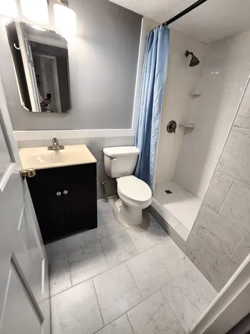 a bathroom with a sink vanity mirror and toilet