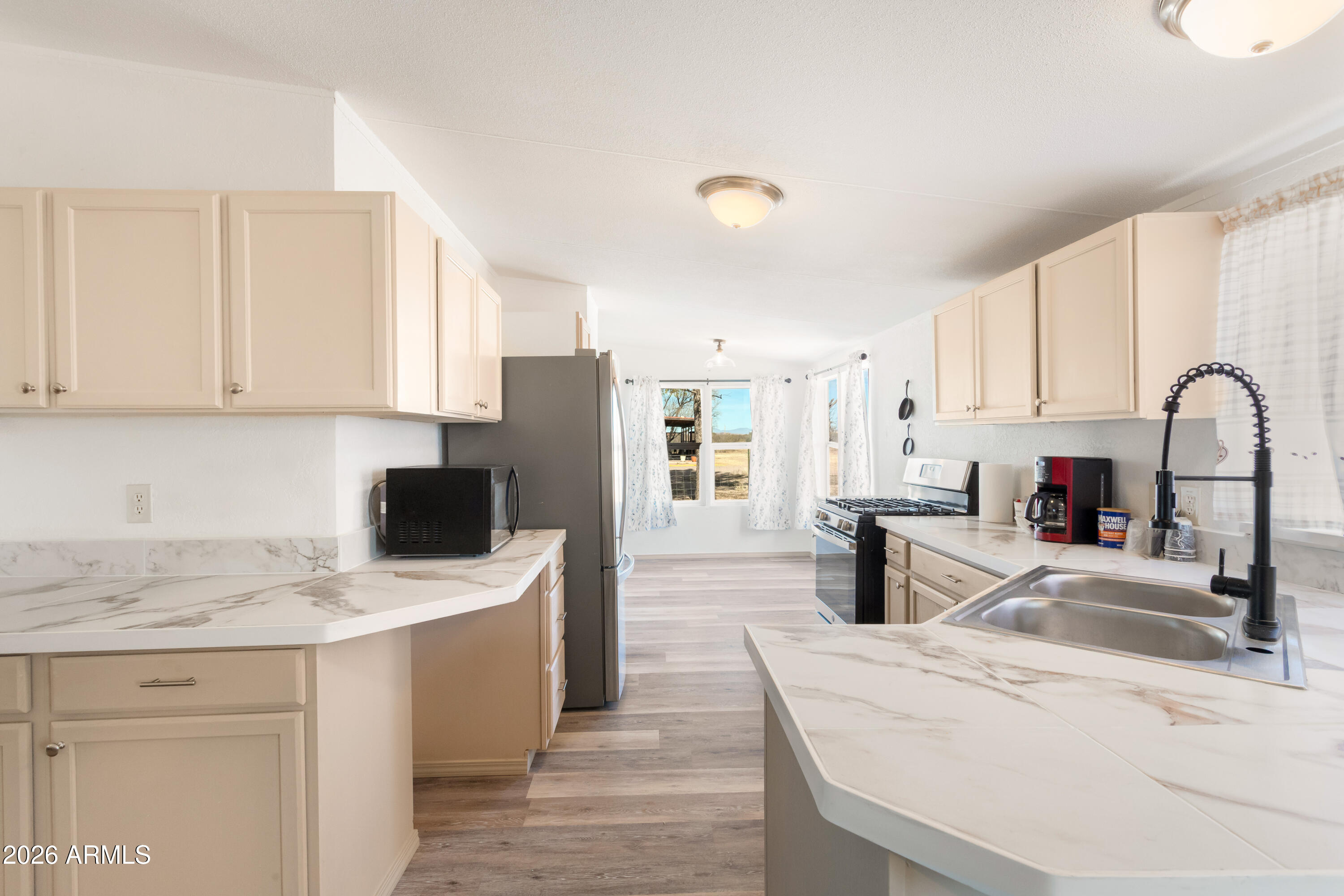 10405 North Mormon Road Elfrida, AZ 85610 - Photo 13 of 43 a kitchen with a refrigerator sink and white cabinets