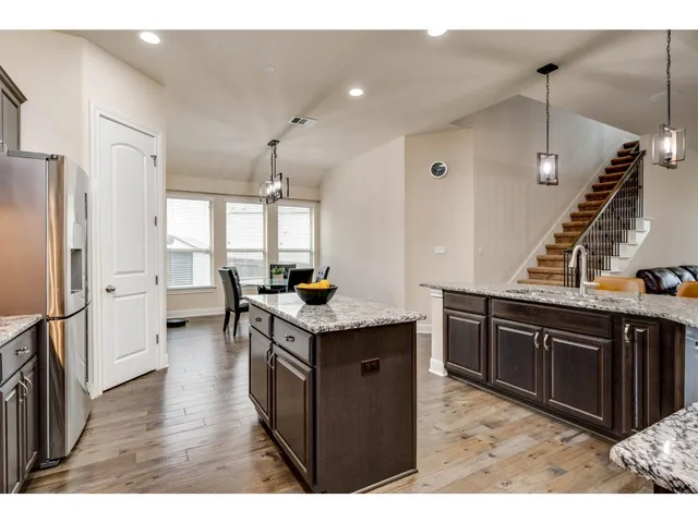 a kitchen with a refrigerator a sink and wooden cabinets