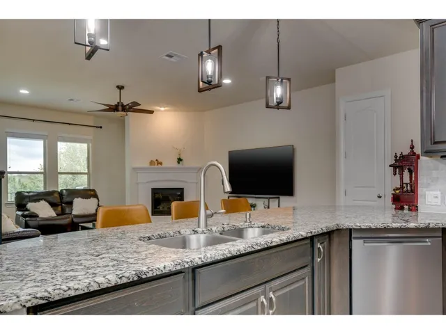 a kitchen with granite countertop a sink stainless steel appliances and a counter top space