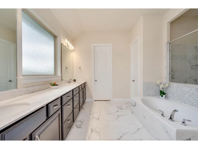 a bathroom with a tub a sink and a mirror