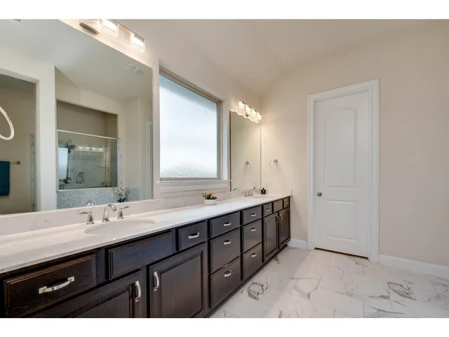 a bathroom with a double vanity sink and mirror