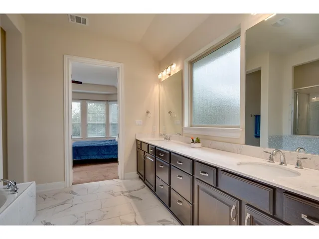 a bathroom with a double vanity sink and mirror