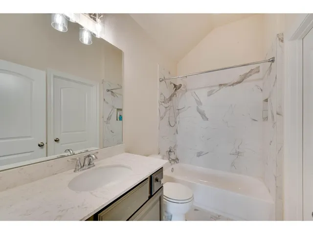 a bathroom with a sink mirror toilet and bathtub