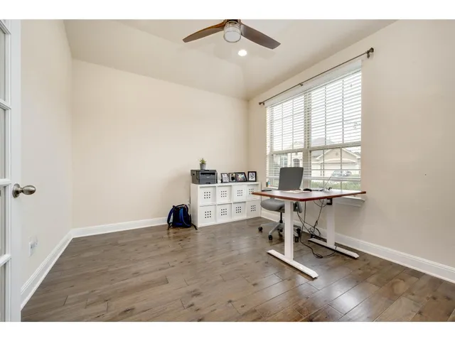 a view of a workspace with furniture and a window